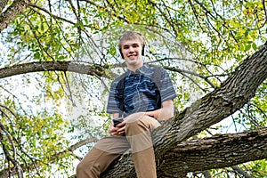 Student listening to music in a tree.