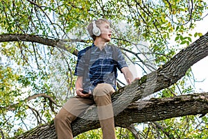 Student listening to music in a tree.