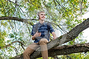 Student listening to music in a tree.