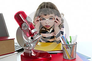 Student little girl with microscope and laptop