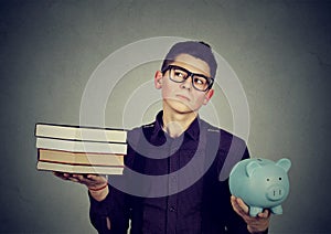 Student loan concept. Man with pile of books piggy bank full of debt