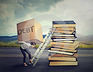 Student loan debt. Woman with heavy box debt carrying it up education ladder photo