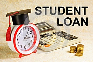 Student loan. An inscription on the background of coins, a calculator and a planning clock.