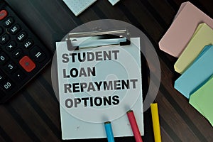 Student Loan Repayment Options write on a paperwork isolated on Wooden Table. Educational concept photo