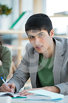 student looking at camera and making notes