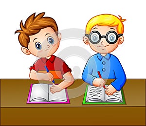 A Student looking over the notebook of his seatmate