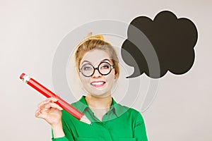 Woman holding big oversized pencil thinking