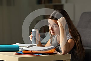 Student memorizing holding and energy drink in the night photo