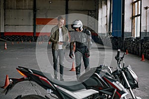 Student motorcyclist and instructor discussing rout of future exam race photo