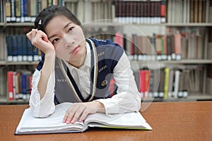 Student with open textbook deep in thought