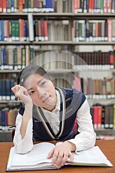 Student with open textbook deep in thought