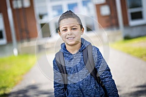 Student outside school standing smiling