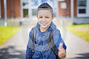 Student outside school standing smiling