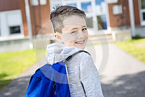 Student outside school standing smiling