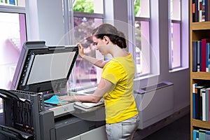 Student photocopying her book in the library