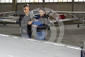 Student Pilot and Flight Instructor Check an Aircraft for Safety in a Hangar