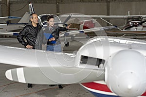 Student Pilot and Instructor Check an Aircraft for Safety in a Hangar