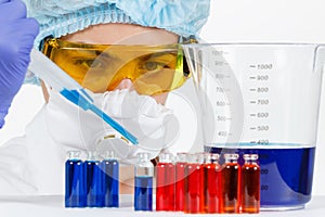 Student with pipette, protective clothing, glasses in a chemistry lab