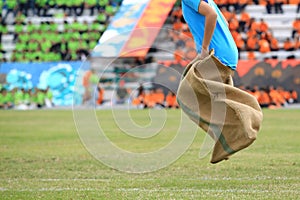 Student play running sack during sports day. Thailand.