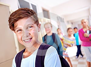 Student, portrait and boy with smile in hallway with education, study and backpack for back to school. Youth, young kid