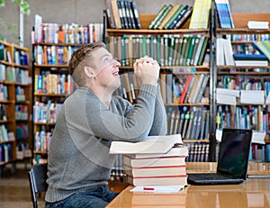 Student prays before examination in a library photo