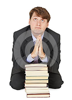 Student prays before examination on textbooks