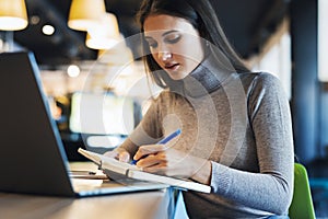 A student prepares seminar, writes notes in notebook, searches information on Internet, uses the Internet, online