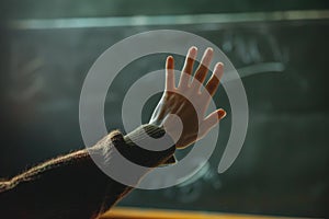 Student raising hand answering question on chalkboard