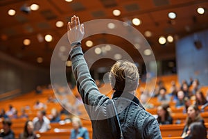 Student Raising Hand in University Lecture Hall.