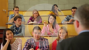 Student raising her hand to ask question in lecture