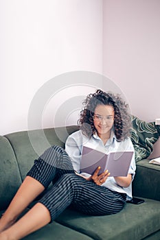 Student reading book from cover to cover at home