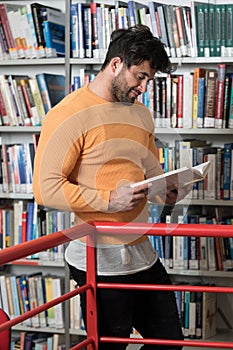 Student Reading from Book in a Library