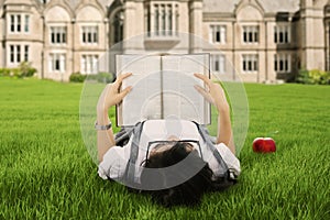 A student reading a book outdoor