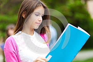 Student reading a book at the park