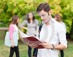 Student reading a book at the park