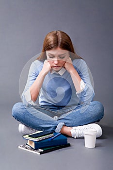 Student reading book sitting on the floor. Student concept. Studio