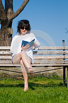 Student reads the book sitting on a bench