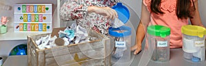 Student recycling cardboard on selective trash bin in ecology classroom