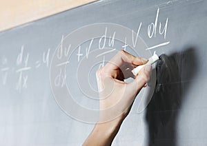 Student's hand solving maths problem