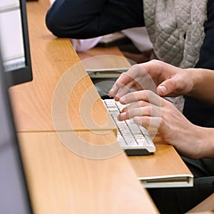Student's hands at the computer keyboard in computer classroom