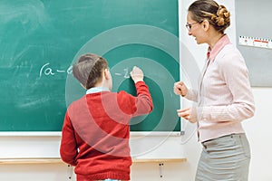 Student in school doing exercise at the blackboard