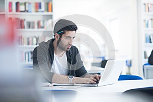 Student in school library using laptop for research