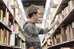Student selecting a book in a library photo