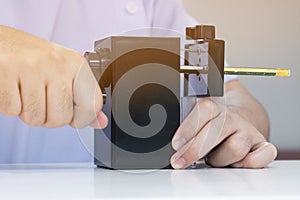 Student is sharpening a pencil By black Sharpener in school