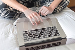 College student working on laptop on bed