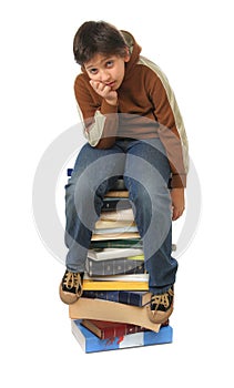 Student sitting on a pile of books