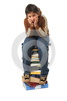 Student sitting on a pile of books