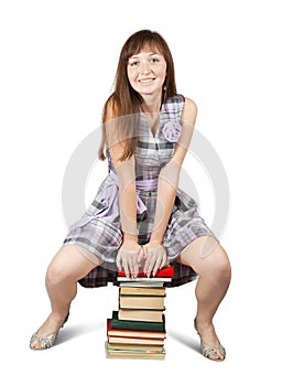 Student sitting on pile of books