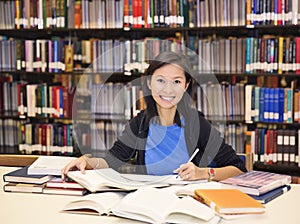 Student sitting and reading book in library