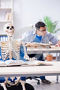 The student skeleton listening to lecture in classroom
